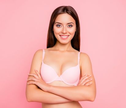 Junge Frau glücklich über Brust-OP mit internem BH